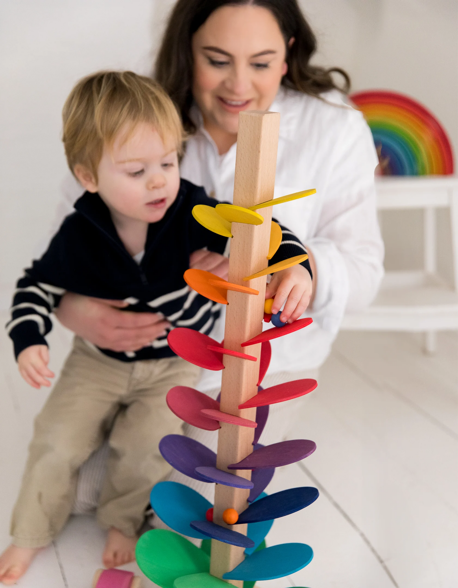 Woman and child playing with a colorful wooden toy