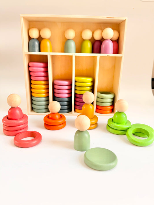 Colorful wooden toys including rings and figures displayed on a white surface.