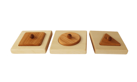 Montessori puzzle with square, circle, and triangle shapes for fine motor skill development.