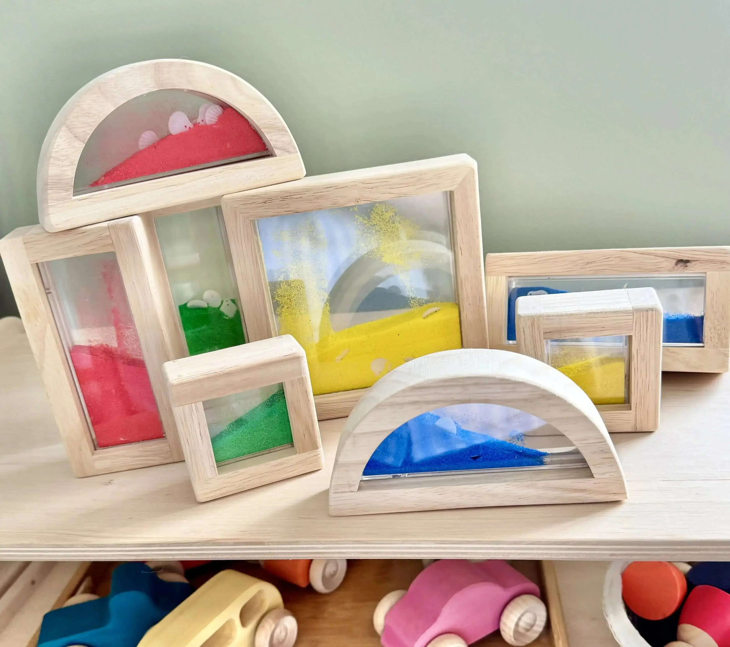 Montessori-inspired wooden sand blocks for open-ended play and shape recognition. Eco-friendly toy set with vibrant moving sand and shells.