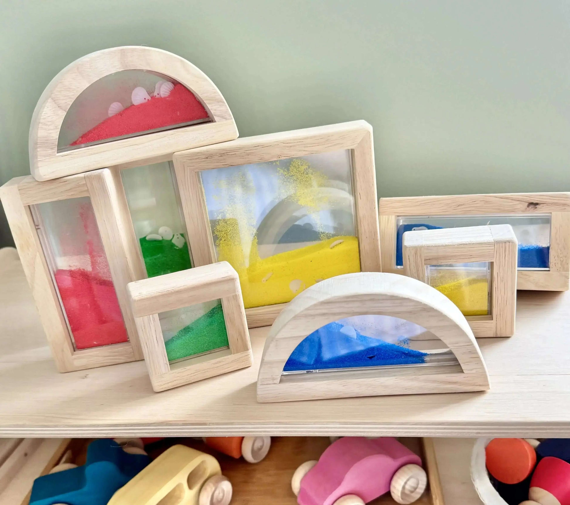 Montessori-inspired wooden sand blocks for open-ended play and shape recognition. Eco-friendly toy set with vibrant moving sand and shells.