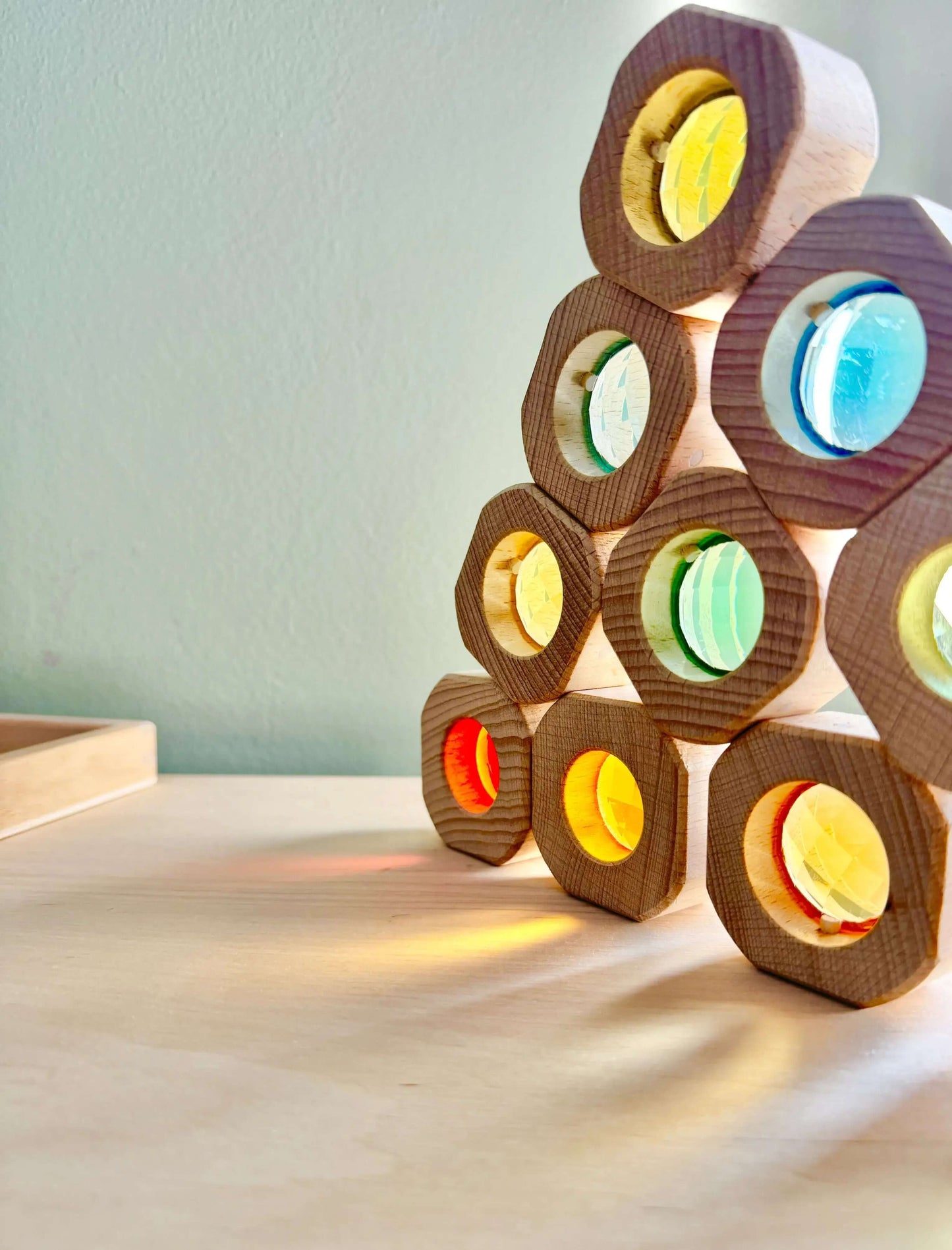 Wooden & Acrylic Light Blocks for open-ended play and Montessori inspired, eco-friendly toy, stacked on table with colorful reflections.