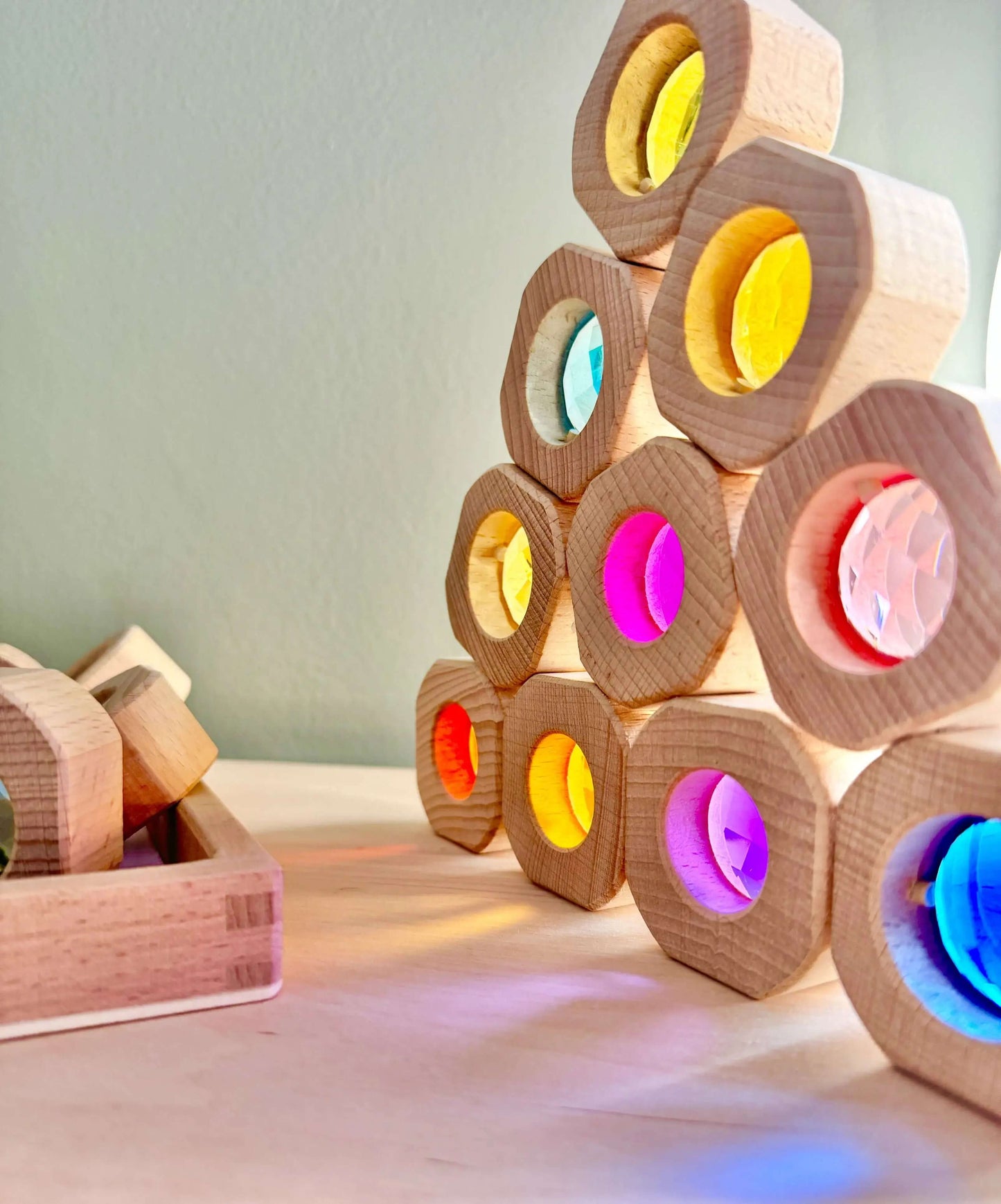 Wooden and acrylic light blocks arranged in a pyramid, showcasing colorful illuminated centers.