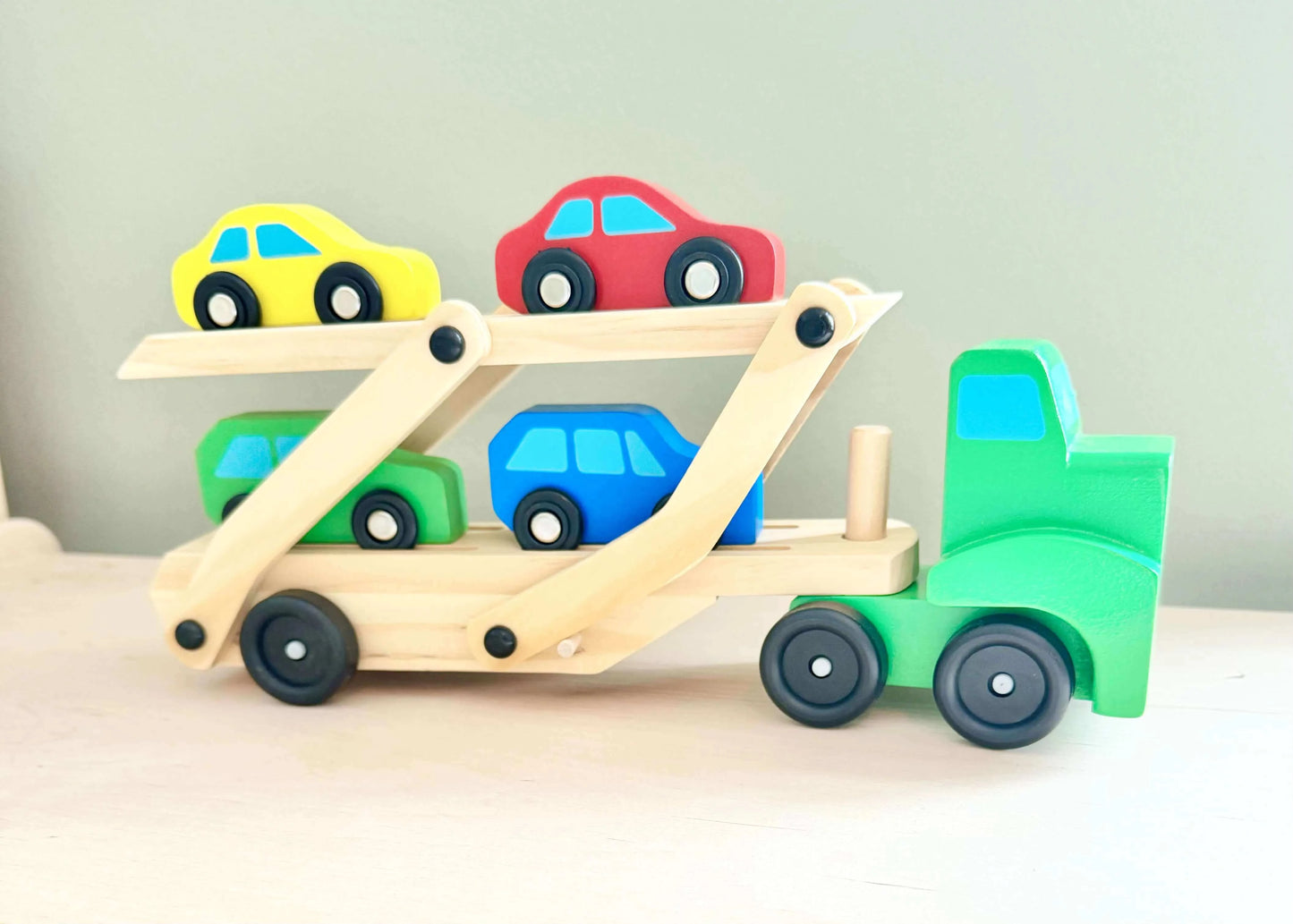 Wooden toy car carrier with colorful cars, Montessori inspired for open-ended and eco-friendly play, suitable for young children.