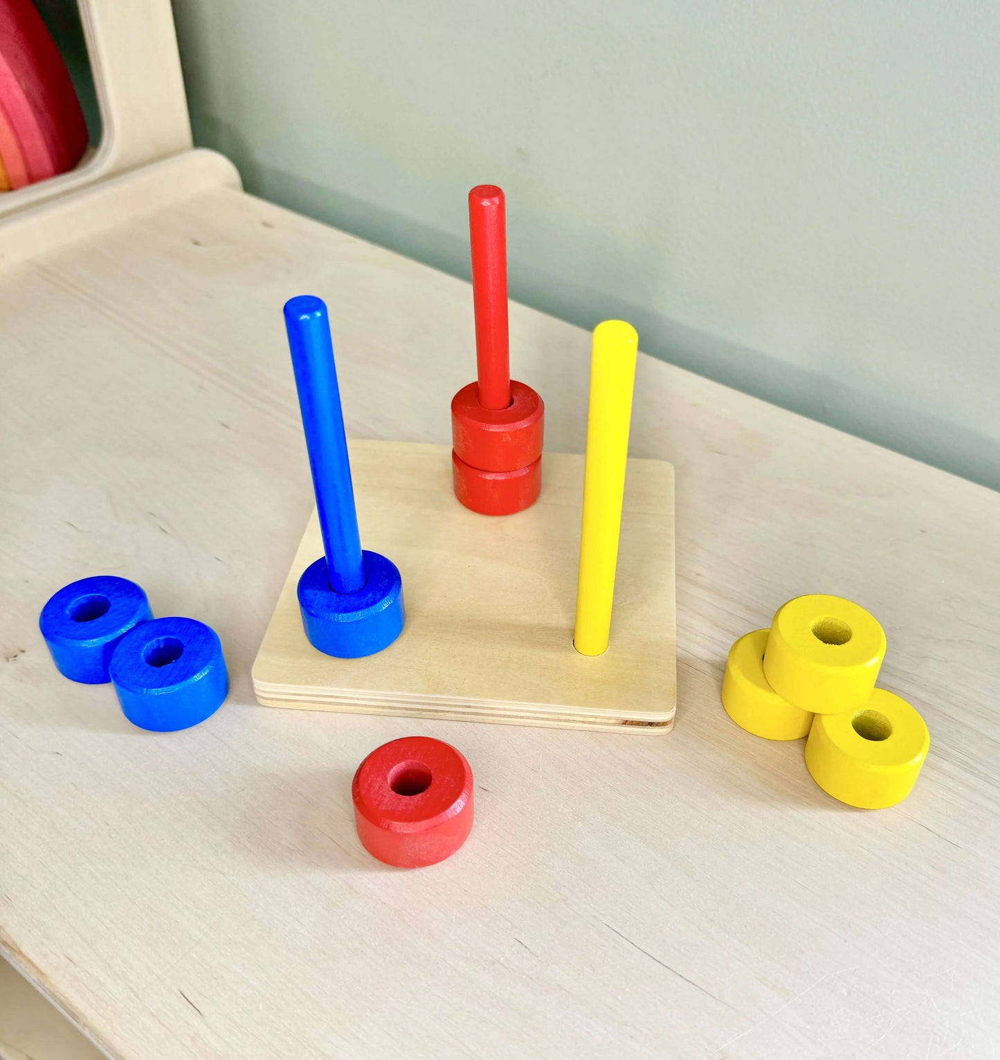 Coloured dowels and rings Montessori-inspired wooden toy for open-ended play, promoting fine motor skills and hand-eye coordination. Eco-friendly, safe.