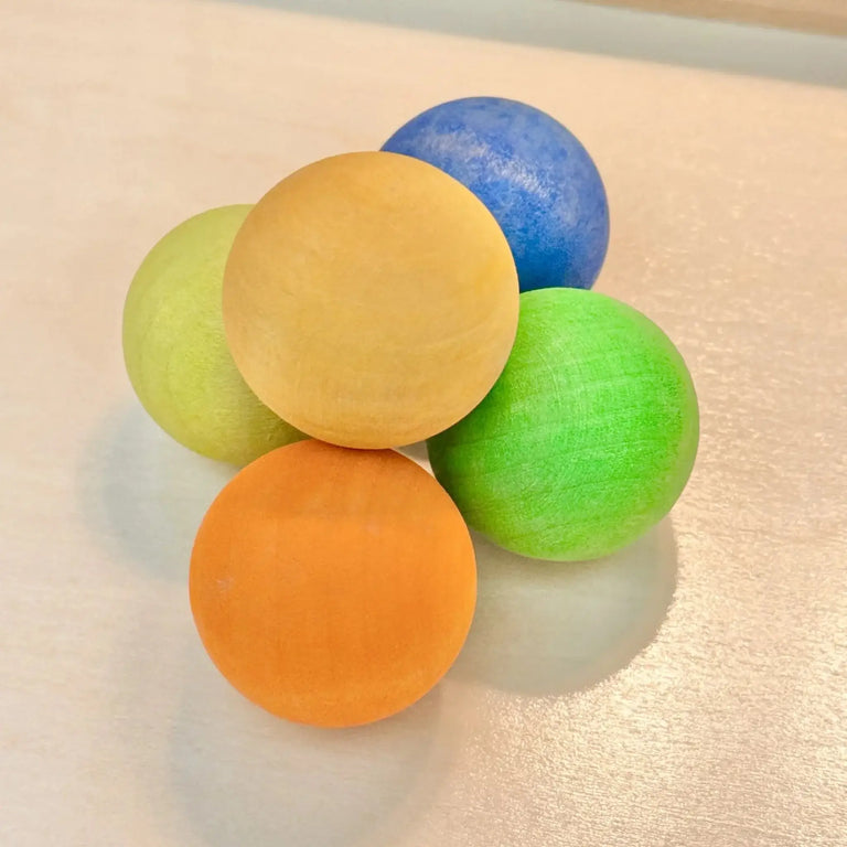 Set of five large wooden marbles in vibrant colors for safe, imaginative play and sensory exploration.