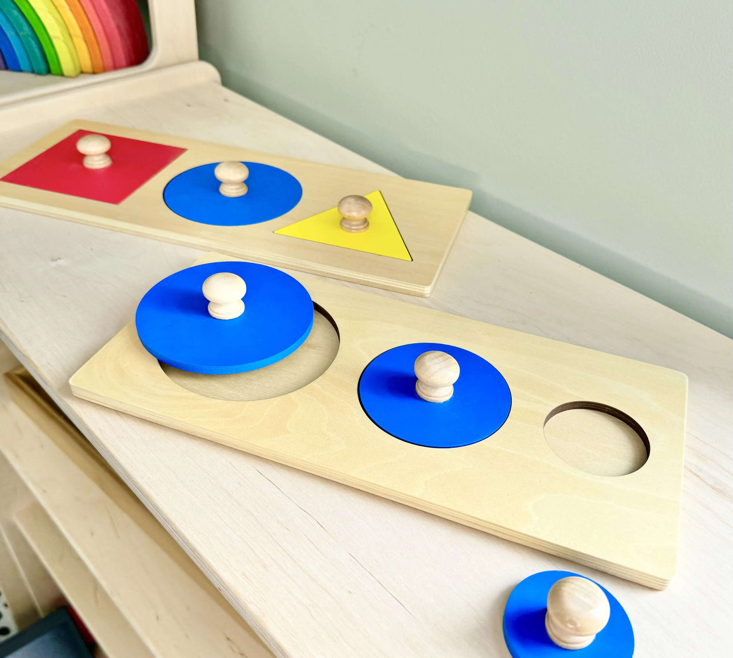 Montessori inspired wooden toy puzzle set with colorful shapes and circles on a wooden table for open-ended play and spatial learning