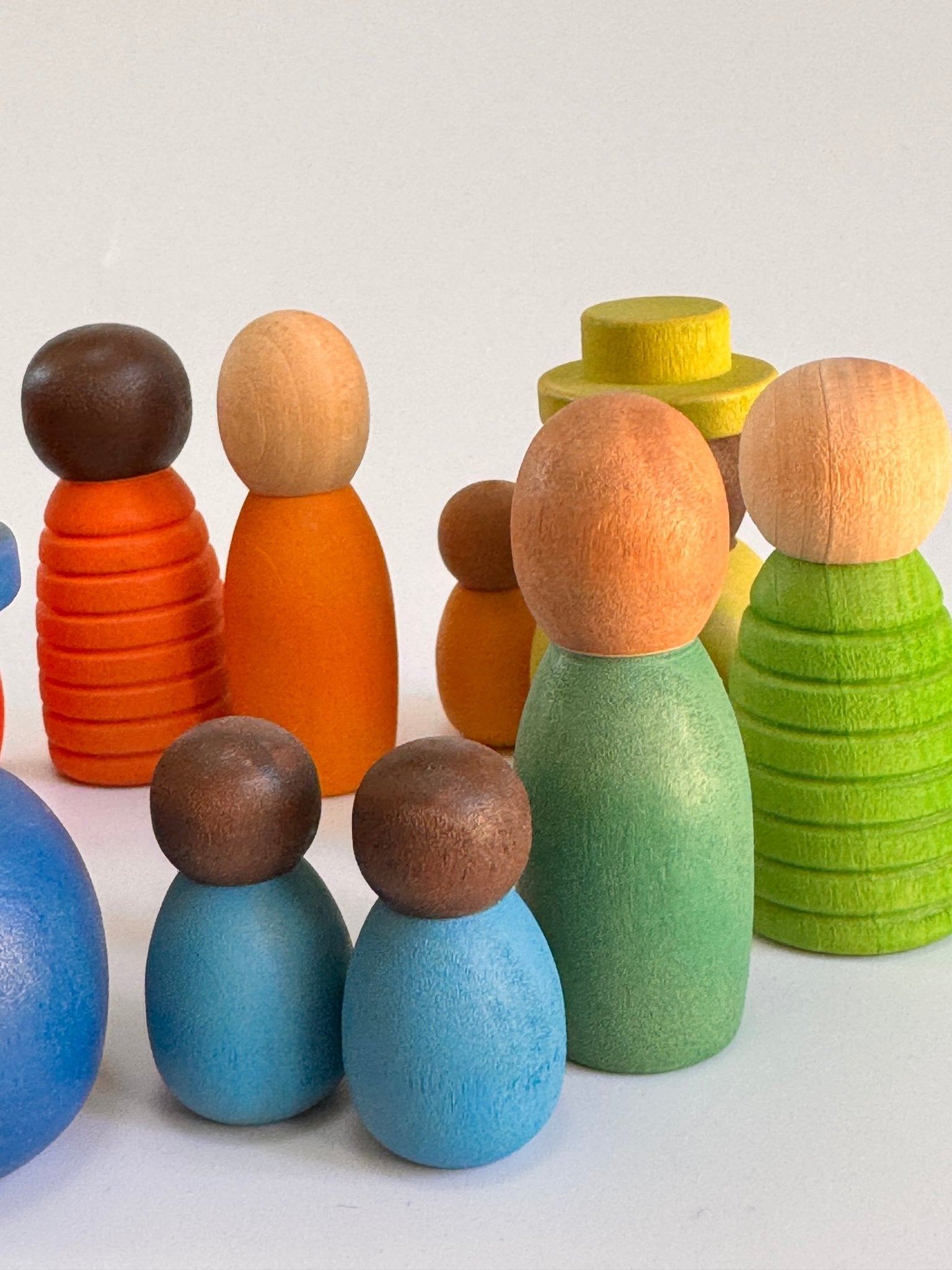 Colorful set of wooden peg dolls in various shapes and sizes, celebrating diversity and imaginative play.