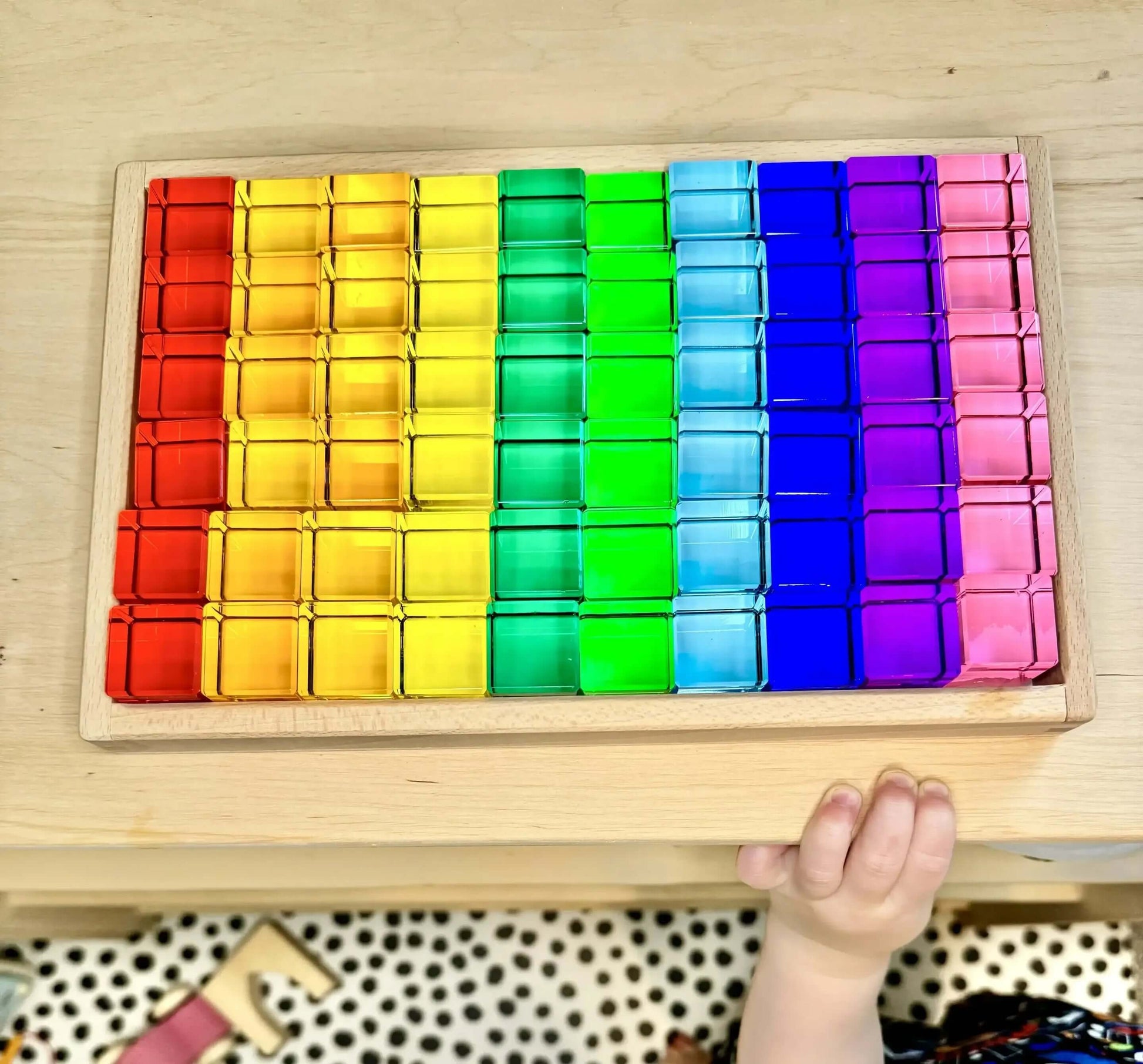 Vibrant acrylic Permeability Cubes set arranged in a wooden tray, perfect for open-ended Montessori inspired play and learning.