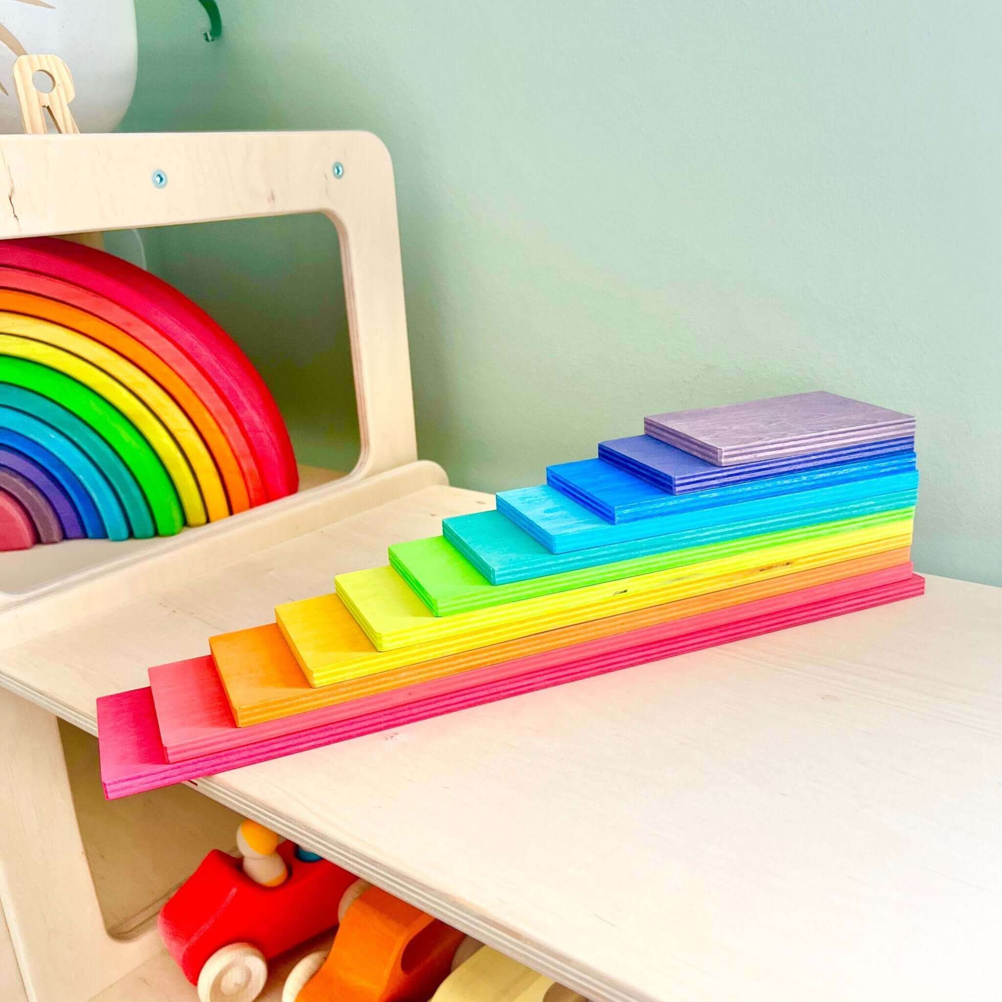 Wooden Rainbow Building Boards and other Montessori inspired toys on a table for open-ended, imaginative play.