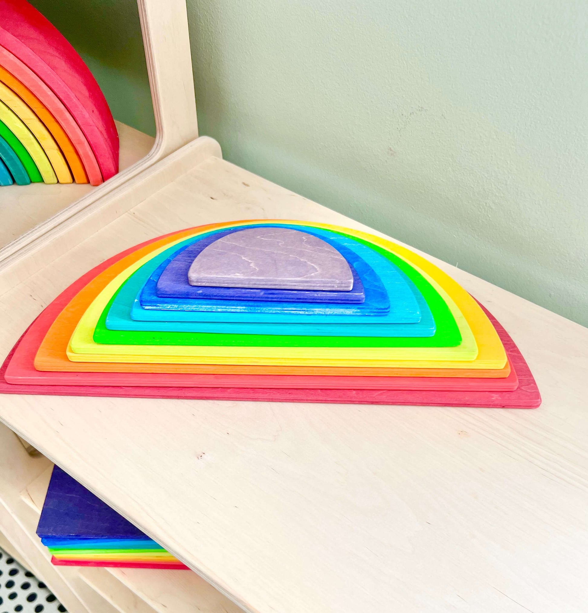 Montessori wooden rainbow semi-circles for toddlers, promoting eco-friendly, open-ended play and early sensory exploration