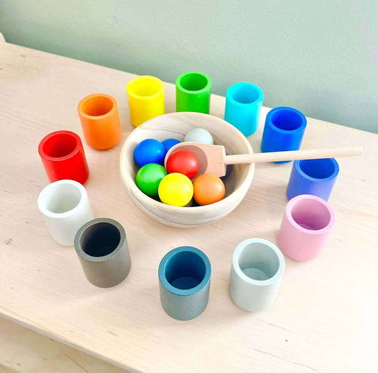 Brightly colored sorting cups with matching balls, wooden bowl, and spoon. Eco-friendly Montessori-inspired wooden toy for open-ended play.