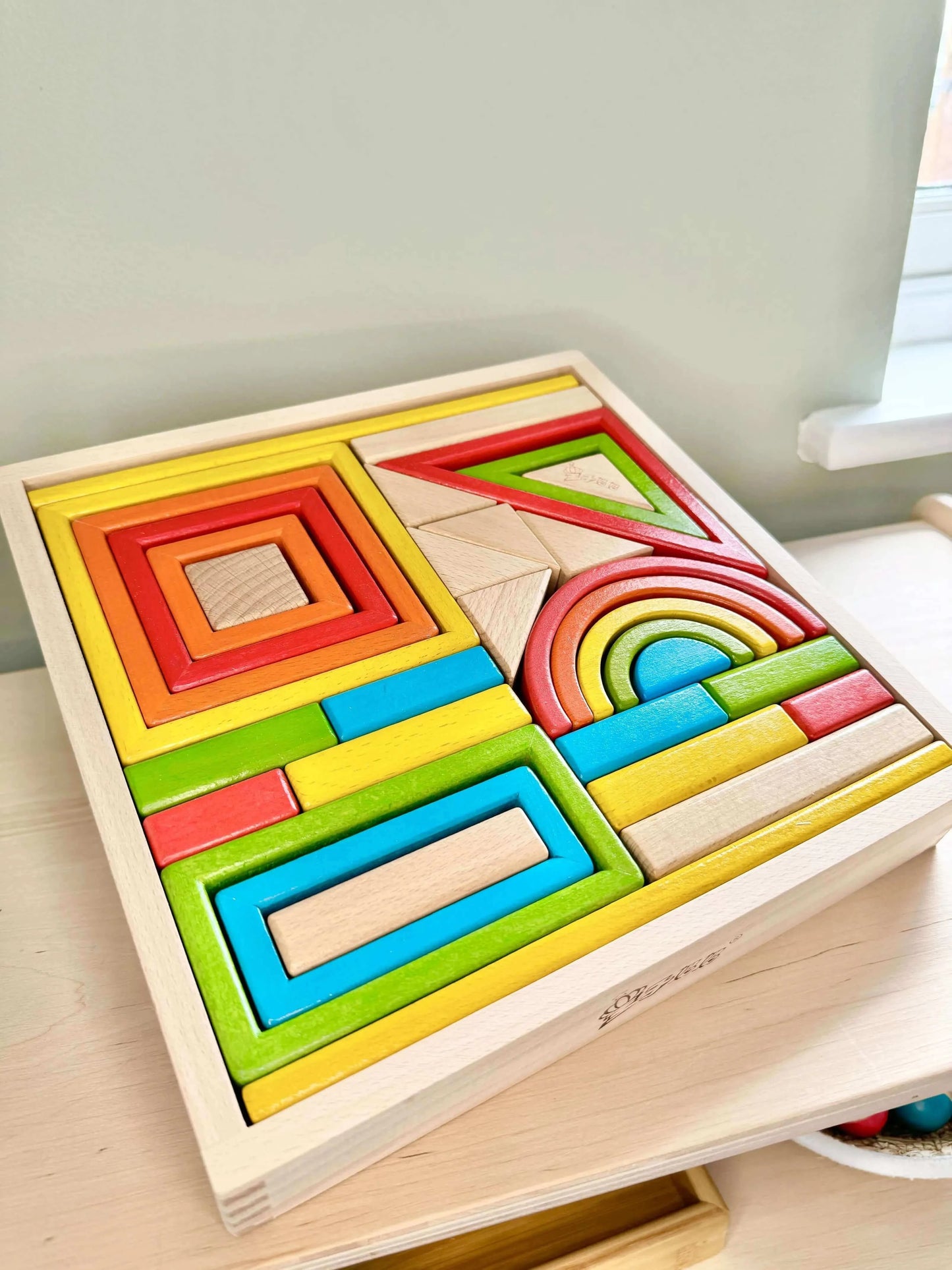 Colorful wooden hollow blocks in a square frame, ideal for Montessori-inspired open-ended play and eco-friendly imaginative fun.